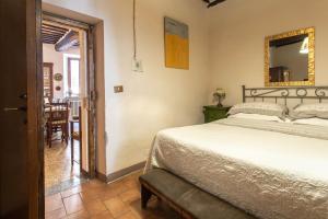 a bedroom with a bed and a mirror on the wall at Guesthouse da Idolina dal 1946 in Montalcino +59 photos