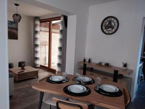 a dining room with a table with chairs and a clock at l 'Escale in Roye
