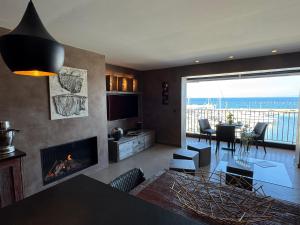a living room with a fireplace and a view of the ocean at Port de Hyères Terrasse vue mer parking privé 2 SDB plage à pied in Hyères