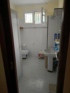 a bathroom with a toilet and a sink at Villa per famiglia in Fontane Bianche +3 photos