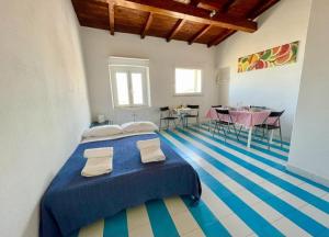 una camera con letto blu e tavolo e sedie di La Casa degli Affreschi a Sperlonga