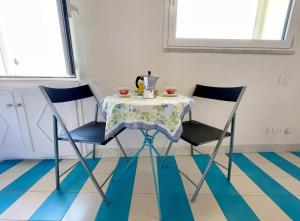 un tavolo con due sedie e una teiera sopra di La Casa degli Affreschi a Sperlonga Altre 10 foto