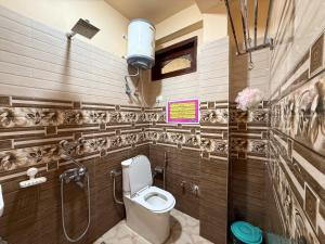 a bathroom with a toilet and a sign on the wall at Grham Hostel & Cafe Kasol, Katagla in Kasol