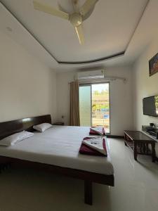 ein Schlafzimmer mit großem Bett und Fenster in der Unterkunft Raya Retreat Resort in Alībāg