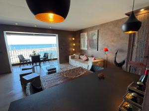 a living room with a couch and a table at Port de Hyères Terrasse vue mer parking privé 2 SDB plage à pied in Hyères