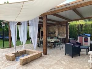 a covered patio with a table and chairs at La Huerta in Alcañiz