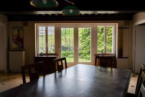 a dining room with a large wooden table and windows at La Picherotte in Anost