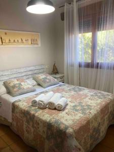 a bedroom with a bed with two pillows and a window at La Huerta in Alcañiz