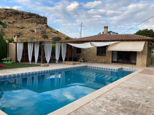 a villa with a swimming pool in front of a house at La Huerta in Alcañiz