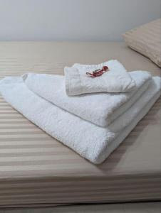 una pila de toallas blancas en una cama en Moonflower residence 4645, en Bishkek