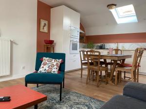 a living room with a table and a kitchen at Chez Catherine in Vorey
