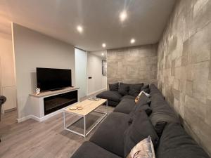 a living room with a couch and a tv at Villa Aneto - Confort moderno en el corazón de Benasque in Benasque