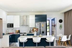 a kitchen with a table and some white chairs at Sikhaleni in Manzini