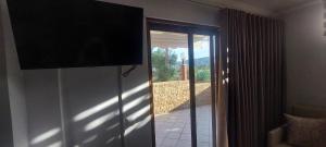 a flat screen tv on a wall next to a door at Petrino 2 semibased by Vasileia in Sarti