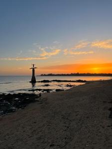 a view of the christ the redeemer on the beach at sunset at Appartement 2 chambres, centre ville, proche mer in Saint-Nazaire +1 photo