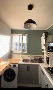 a kitchen with a sink and a washing machine at Appartement 2 chambres, centre ville, proche mer in Saint-Nazaire