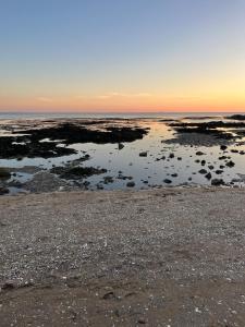 a view of the beach at sunset at Appartement 2 chambres, centre ville, proche mer in Saint-Nazaire
