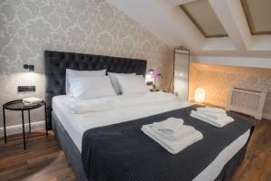 a bedroom with a large bed with two towels on it at Benvenuti DELUXE in Belgrade +22 photos