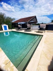 a swimming pool with chairs and a gazebo at Maison de campagne Piscine, jacuzzi 2P Monflanquin in Savignac-sur-Leyze
