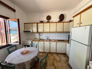 a kitchen with a table and a white refrigerator at Sea View in Kámpos +13 photos