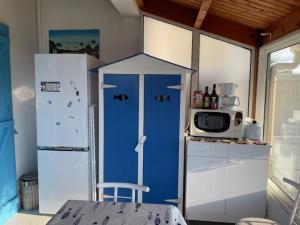 a kitchen with a blue refrigerator and a microwave at Entre mer et centre-ville in La Tranche-sur-Mer