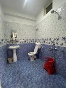 a blue bathroom with a toilet and a sink at Sky Club Bir Hospitality in Bīr