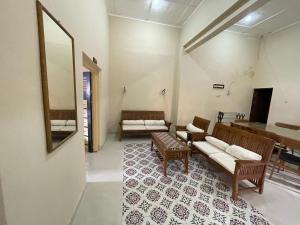 a living room with two couches and a mirror at D'Dalem Kadipaten Homestay in Yogyakarta