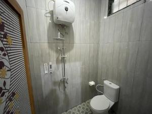 a bathroom with a toilet and a shower in it at D'Dalem Kadipaten Homestay in Yogyakarta +38 photos