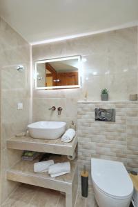 a bathroom with a sink and a toilet and a mirror at Magnolia House Stafylos in Skopelos Town +32 photos