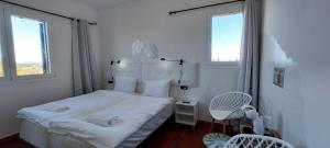 a white bedroom with a bed and two windows at Landhuisvilla b&b Villa Pardalot in Cálig +59 photos