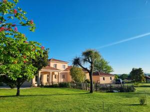 a house with a fence in a yard with trees at Chambre a la campagne in Saint-Martin-de-Jussac