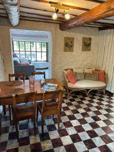 a living room with a table and chairs and a couch at Little Roua Ardenne Cottage 4 pers in Stoumont