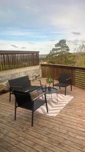 a patio with two chairs and a table on a deck at Moderne Leilighet med panorama utsikt in Sandefjord