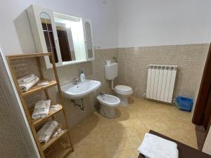 a bathroom with a sink and a toilet and a mirror at PIAZZETTA DEL FORNO appartamento in Assergi
