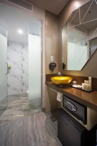 a bathroom with a yellow sink and a mirror at Hotel Clover 7 in Singapore