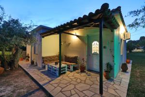 a patio with a bench under a pergola at Magnolia House Stafylos in Skopelos Town