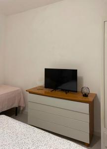 a tv on top of a dresser in a bedroom at La casa di Nenni in Santa Giusta