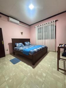 a bedroom with a bed with blue sheets and a window at bonjour villa rathgama in Rathgama +2 photos