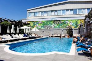 a swimming pool in front of a building at Benvenuti DELUXE in Belgrade