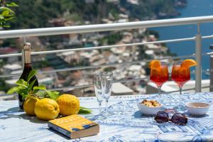 a table with glasses and a bottle of wine and fruit at La Casa di Bruno in Positano