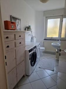 a bathroom with a washing machine and a sink at Gemütliche Ferienwohnung in Karlsruhe in Karlsruhe