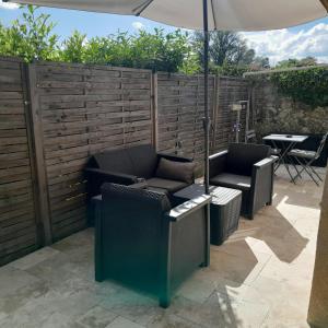 a patio with two chairs and an umbrella at Studio route de Gougues in Saint-Caprais-de-Bordeaux
