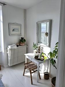 a white room with a table and a window at La Maison Ânanda in Aigre