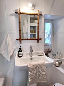 a white bathroom with a sink and a mirror at La Maison Ânanda in Aigre