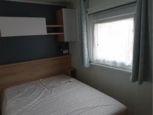 a small bedroom with a bed and a window at CAMPING Les EMBRUNS - 4 ETOILES in Lège-Cap-Ferret