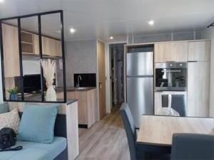 a living room with a kitchen and a dining room at CAMPING Les EMBRUNS - 4 ETOILES in Lège-Cap-Ferret +7 photos
