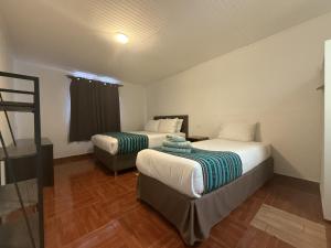 a hotel room with two beds and a ladder at Ckoinatur Hostel in San Pedro de Atacama