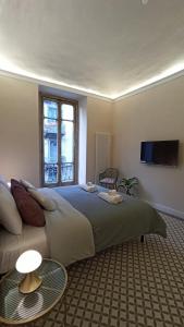 a bedroom with a bed and a couch and a tv at Brindisina Apartment in Turin +19 photos
