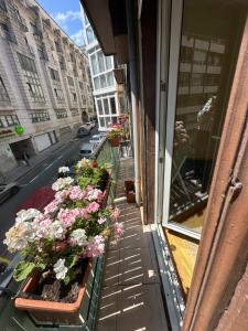a balcony with flowers on the side of a building at Días de Sur in Santander