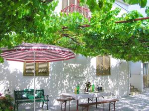 a table and two chairs under an umbrella at Holiday House Jure in Senj